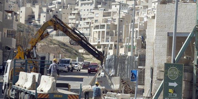 Labourers work at a housing construction site in the Israeli settlement of Har Homa in east Jerusalem on February 27, 2013. Israeli Housing Minister Uri Ariel implied that a silent freeze on new housing projects in east Jerusalem and the West Bank has been in place since the beginning of 2013.
