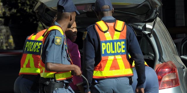 Police check people arriving at the Medi-Clinic Heart Hospital in Pretoria, last week. A South African police commander was found murdered in a field with his hands and feet bound in the early hours of Tuesday, a police commissioner said.