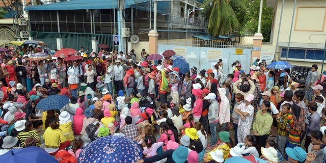 Cambodian garment factory workers sit as they block a street during a protest in front of a factory in Phnom Penh on June 19, 2013. Cambodia's strongman Prime Minister Hun Sen on Wednesday warned garment workers that protests demanding higher wages could push manufacturers to quit the country.
