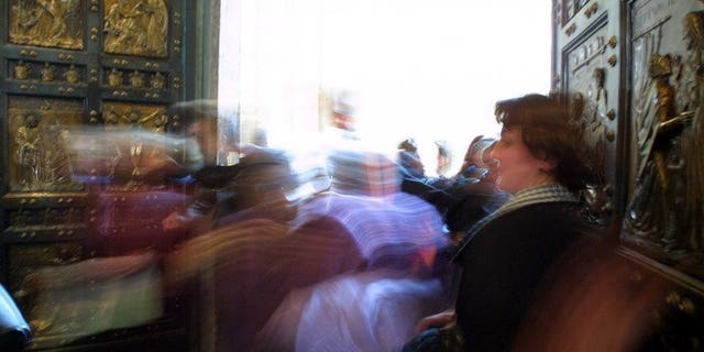 Pilgrims cross the Holy Door in Saint Peter's Basilica, Rome, January 5, 2001. The first Holy door outside of Europe will soon grace one of the oldest Catholic parishes in North America, in the Canadian province of Quebec, a church official told AFP on Wednesday.