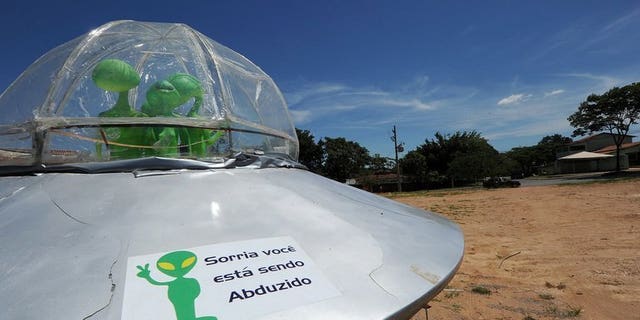 File picture shows a mock UFO with a sign reading "Smile, you are being abducted" north of Brasilia, December 2012. Britain's defence ministry shut down its UFO unit four years ago after concluding that extra-terrestrials likely did not exist, and in any case did not pose a threat, previously secret files released on Friday showed.