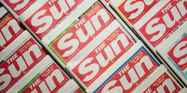 Picture shows an arrangement of copies of The Sun tabloid on February 13, 2012. Two journalists from Rupert Murdoch's The Sun were charged in Britain on Friday, accused of paying officials for information about hospital patients, the royal family and ongoing police investigations.