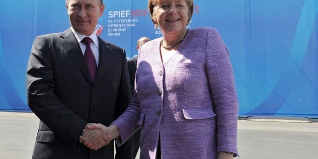 Russia's President Vladimir Putin (L) and Germany's Chancellor Angela Merkel meet during an International Economic Forum in St Petersburg, on June 21, 2013. Putin and Merkel on Friday announced that they would both attend the opening of a Saint Petersburg exhibition that includes treasures taken by the Red Army at the end of World War II.