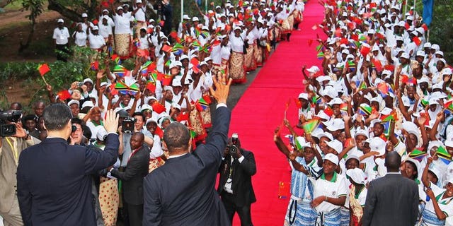 Chinese President Xi Jinping (L) and Tanzanian President Jakaya Kikwete (R) wave to crowds in Dar Es Salaam on March 24, 2013. World leaders visit Africa relatively little, but Tanzania is preparing to host US President Barack Obama just three months since a state visit the Chinese leader.