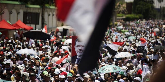 Egyptian Islamist groups led by the ruling Muslim Brotherhood take part in a demonstration to mark the upcoming one year anniversary since President Mohamed Morsi (portrait) was elected, on June 21, 2013 in Cairo. Morsi has repeated a call for dialogue with the opposition in an attempt to mitigate deep political divisions ahead of planned rallies later this month calling for his resignation.