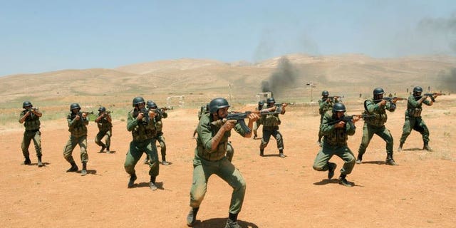 Syrian government soldiers take part in a training exercise at an undisclosed training camp in Syria on may 22, 2013. US Secretary of State John Kerry says supporters of the Syrian opposition will step up military and other aid in a bid to end an "imbalance" on the ground in President Bashar al-Assad's favour.