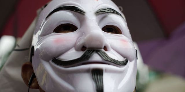 A protester wearing a Guy Fawkes mask attends a rally in Bangkok's shopping district on June 23, 2013. Hundreds of anti-government protesters -- many wearing Guy Fawkes masks -- converged in Bangkok, in a reminder of the kingdom's political divisions.