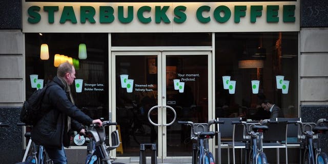 A man parks his hire bicycle outside a branch of Starbucks in central London on February 1, 2013. The US-based coffee giant has said it had paid ??5 million in British corporation tax and will pay another ??15 million by next year after facing a backlash from lawmakers and customers over non-payment.
