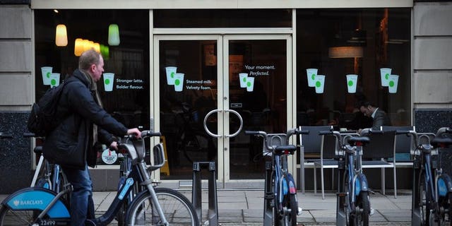 A man parks his hire bicycle outside a branch of Starbucks in central London on February 1, 2013. The US-based coffee giant has said it had paid ??5 million in British corporation tax and will pay another ??15 million by next year after facing a backlash from lawmakers and customers over non-payment.