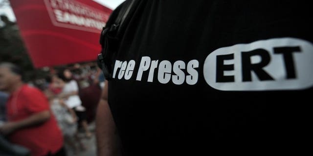 An opposition supporter wears a "Free Press ERT" T-shirt during a rally in Athens, on June 17, 2013. As debate swirls in Greece over the future of public broadcasting, analysts say the abrupt shutdown of state broadcaster ERT is only the latest problem to hit Greece's chaotic media scene.