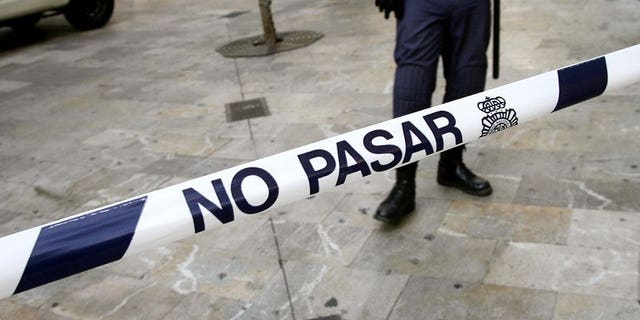 Spanish security personnel man a police cordon. A woman has been arrested for attempted murder after her two-day old baby was discovered inside a building's drains in Alicante and painstakingly rescued by firefighters.