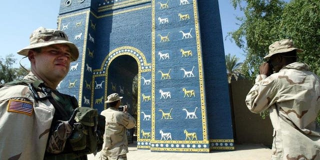 US soldiers take pictures of the Ishtar Gate in the ancient city of Babylon, on September 28, 2003. At ancient Babylon's Ishtar Gate -- workers labour with a heavy saw, hammers, a chisel and crowbar to break up and remove a concrete slab that is hastening the structure's decay.