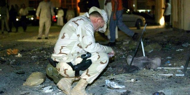 A US Navy officer examines the scene of an explosion near the headquarters of the Navy's Fifth Fleet in Manama on March 24, 2003. The US military has failed to prepare a realistic "plan B" if political turmoil forces the closure of the vital naval base in Bahrain, a naval officer argues in a report released Monday.
