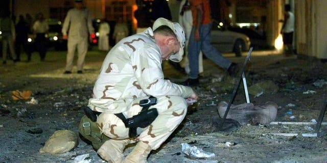 A US Navy officer examines the scene of an explosion near the headquarters of the Navy's Fifth Fleet in Manama on March 24, 2003. The US military has failed to prepare a realistic "plan B" if political turmoil forces the closure of the vital naval base in Bahrain, a naval officer argues in a report released Monday.