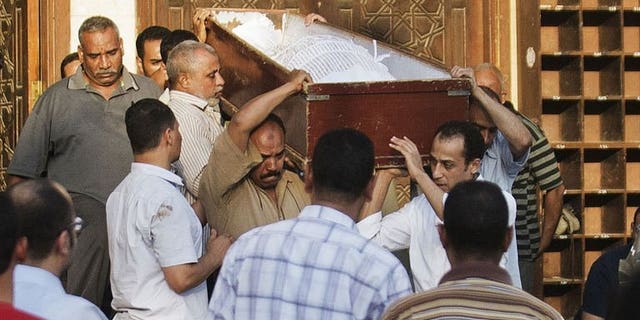 People carry the coffin of a Shiite man killed the previous night by a mob along with three others, during his funeral in El-Sayeda Nafisa Mosque in Cairo on June 24, 2013. Security forces have arrested eight people in connection with the brutal killing of four Egyptian Shiites in a village south of Cairo, officials said on Tuesday.
