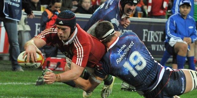 British and Irish Lions' flanker Sean O'Brien (left) dives over the try line to score a try against the Melbourne Rebels on June 25, 2013. The Lions scored five tries to beat the Melbourne Rebels 35-0 in their tour game in Melbourne.