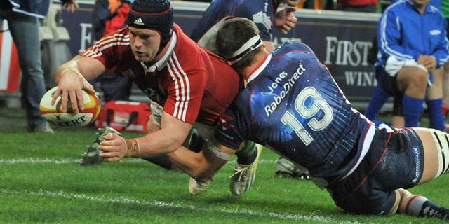 British and Irish Lions' flanker Sean O'Brien (left) dives over the try line to score a try against the Melbourne Rebels on June 25, 2013. The Lions scored five tries to beat the Melbourne Rebels 35-0 in their tour game in Melbourne.