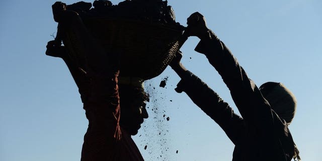 In this photograph taken on January 31, 2013, miners haul baskets full of coal as they load a truck with coal at a road side coal depot near Rymbai village in the Indian northeastern state of Meghalaya. Eight coal miners have been beaten to death and three more are critically injured in India's northeastern state of Meghalaya, officials said on Tuesday.
