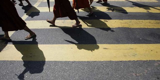 Myanmar Buddhist monks take part in a demonstration against the Organisation of the Islamic Conference in Yangon on October 15, 2012. Myanmar late Tuesday banned a controversial Time magazine cover story on Buddhist-Muslim religious violence "to prevent further conflict", according to a government spokesman, after days of angry reaction to the article.