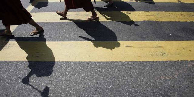 Myanmar Buddhist monks take part in a demonstration against the Organisation of the Islamic Conference in Yangon on October 15, 2012. Myanmar late Tuesday banned a controversial Time magazine cover story on Buddhist-Muslim religious violence "to prevent further conflict", according to a government spokesman, after days of angry reaction to the article.