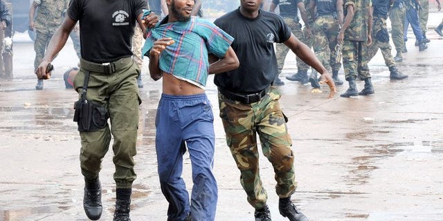 Guinean police arrest a protester on September 28, 2009 in front of the biggest stadium in the capital Conakry during a protest banned by Guinea's ruling junta. Guinean judges have charged a minister in connection with the Conakry Stadium massacre in which at least 157 protesters were killed.