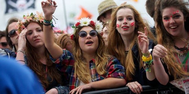 Festival goers attend concerts at the Pyramid Stage during the third day of the Glastonbury Festival, southwest England, on June 28, 2013. The sun was out the world-renowned festival, drying the mud underfoot as tens of thousands waited for the first ever performance by the Rolling Stones.