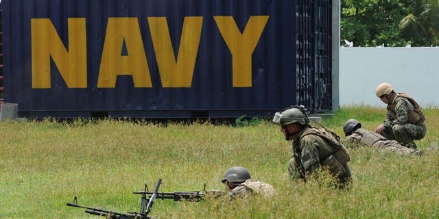 US navy personnel (R) observe their Philippine counterparts during a drill west of Manila on June 28, 2013. The Philippines said that an increasing Chinese military and paramilitary presence in the disputed South China Sea was a threat to regional peace.