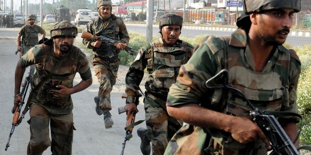Indian soldiers run towards the scene of a deadly attack by armed rebels on the outskirts of Srinagar on June 24, 2013. Soldiers opened fire on demonstrators in restive Kashmir on Sunday, killing one person during protests over the shooting of a teenager in a military operation.