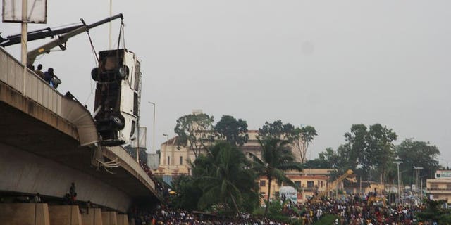 A crane retrieves a minibus from a river after it careered off a bridge just outside of Benin's capital Porto-Novo on June 30, 2013.