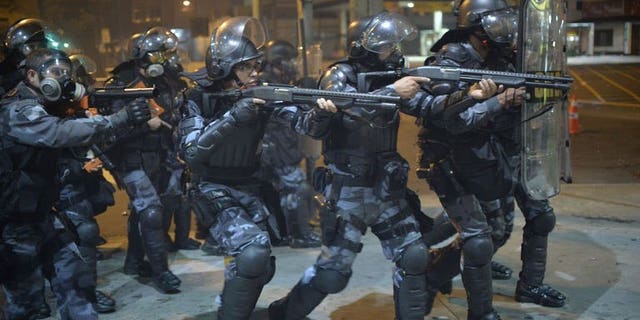 Anti riot police charge during a protest in a street near the Maracana stadium of Rio de Janeiro on June 30, 2013. Protesters clashed with police near Rio's iconic Maracana stadium Sunday, only minutes before the start of the Brazil-Spain final of the Confederations Cup, AFP correspondents reported.
