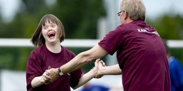 A child with Down's syndrome shares a laugh with Netherlands' TV presenter Jack Spijkerman as they take part in the 'Give Down the Future' football tournament in De Toekomst stadium in Amsterdam on June 29, 2013. A Japanese pharmaceutical company said Monday it will begin therapeutic testing of a drug it hopes will slow the decline in quality of life for some people with Down's syndrome.