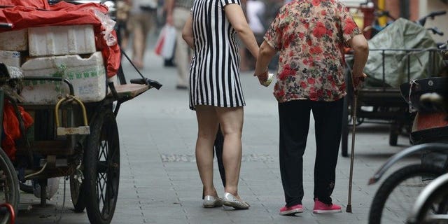 A mother and daughter are seen walking together in Shanghai, on July 1, 2013. The Law on Protection of the Rights and Interests of the Elderly says family members should visit relatives who are aged over 60 "often" -- but does not give a precise definition of the term. More than 14 percent of China's population, or 194 million people, are aged over 60, according to the most recent figures.