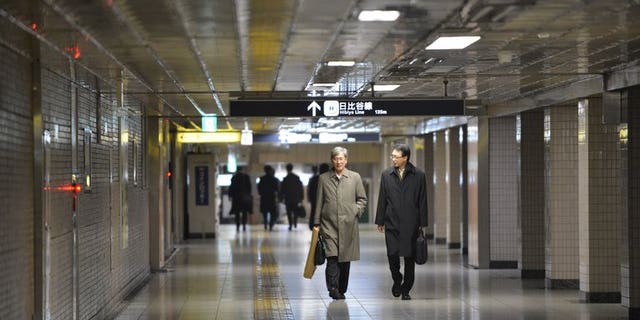 Businessmen walk on a concourse at a subway terminal in downtown Tokyo on December 28, 2012. Japan's army of dark-suited salarymen are scraping by on a monthly allowance from their wives that is less than half what they got in the 1980s bubble years, a survey has shown.
