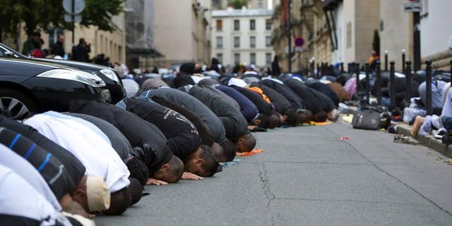 Muslims pray outside the Grande Mosque of Paris on the first day of Eid al-Adha on October 26, 2012.