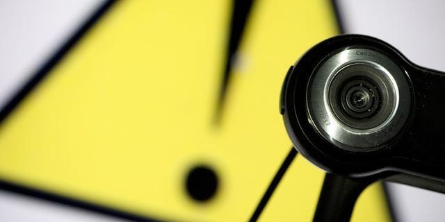 File picture shows a webcam positioned in front of a danger sign in Paris on June 28, 2013. The sexual abuse of children in developing countries is increasingly being live-streamed on Internet services such as Skype, Britain's online child protection agency warned on Tuesday.