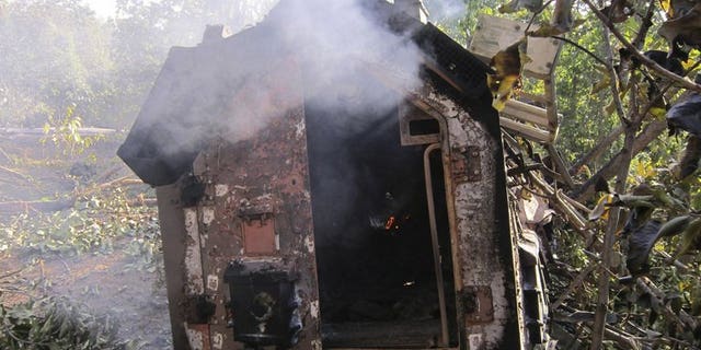 A smouldering police vehicle is seen following a landmine explosion in Garhwa district in India's Jharkhand state on January 21, 2012. A group of more than 50 Maoist guerrillas ambushed a police patrol in eastern India on Tuesday, killing the district police chief and four others, officials said.