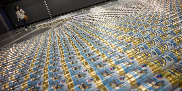A woman walks along a map of China made from more than 1,800 cans of baby formula in a work created by dissident Chinese artist Ai Weiwei in Hong Kong on May 17, 2013