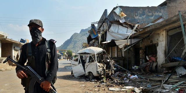 A Pakistani policeman stands guard at the site of a suicide bomb attack in Darra Adam Khel on October 13, 2012. Dozens of heavily armed militants stormed a checkpoint in the northwestern Pakistani tribal area, killing at least six paramilitary police.