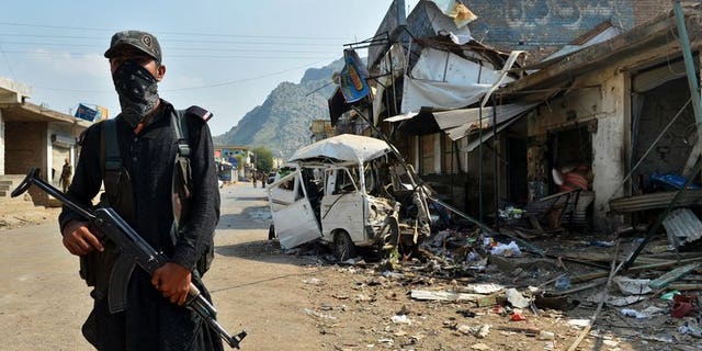 A Pakistani policeman stands guard at the site of a suicide bomb attack in Darra Adam Khel on October 13, 2012. Dozens of heavily armed militants stormed a checkpoint in the northwestern Pakistani tribal area, killing at least six paramilitary police.