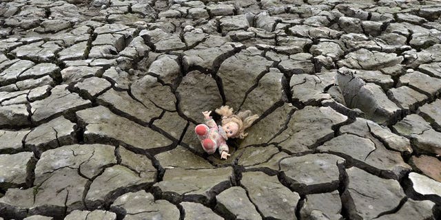 A doll lies on a hole in the dry soil of Los Laureles dam, southern Tegucigalpa, in Honduras on May 22, 2013. The first decade of the 21st century was the hottest on record, marked by unprecedented climate and weather extremes that killed more than 370,000 people, the United Nations weather agency said Wednesday.