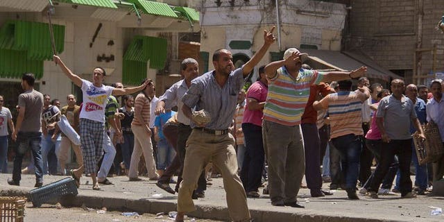 Egyptian opposition protestors hold stones and sticks during clashes with supporters of President Mohamed Morsi in the northern port city of Damietta on June 3, 2013. Elsewhere, four supporters of ousted Egyptian president Mohamed Morsi were killed on Wednesday in clashes with the army and police in the western city of Marsa Matruh, a security official told AFP.