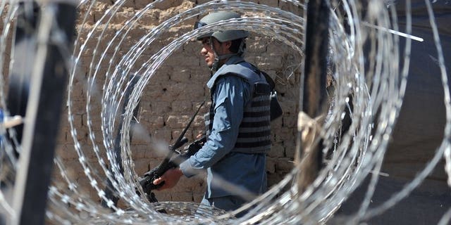 An Afghan policeman patrols in Helmand Province on June 19, 2012. A bomb attack killed four girls attending an Afghan wedding, officials said Thursday, blaming the attack on Taliban rebels intending to target government employees at the event.