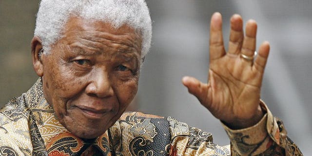 Nelson Mandela waves to the media as he arrives outside No 10 Downing Street in central London, on August 28, 2007. Doctors treating Mandela said that he was in a "permanent vegetative state" and advised his family to turn off his life support machine, according to court documents dated June 26, obtained by AFP.