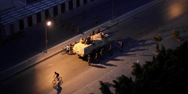 An Egyptian army armored personnel carrier and soldiers are stationed on a street in Cairo following the toppling of ousted Egyptian president Mohamed Morsi on July 4, 2013. An alliance of Islamist parties and movements including ousted president Mohamed Morsi's Muslim Brotherhood has called for "peaceful protests" on Friday to denounce the military's overthrow of the Islamist president.