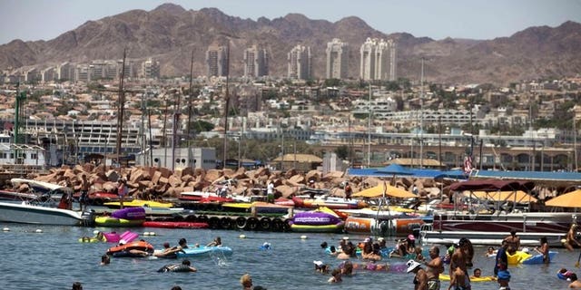 Tourists enjoy the beach in the Red Sea Israeli resort city of Eilat on August 19, 2011. Several explosions were heard Thursday night in Eilat near the Egyptian border, a police spokesman said, adding that the source of the blasts was not known.