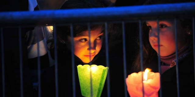 Children hold candles during a prayer vigil at the ancient Circus Maximus Arena in Rome on April 30, 2011, on the eve of the beatification of the late Pope John Paul II. Late popes John Paul II and John XXIII will be made saints of the Roman Catholic Church, the Vatican said on Friday in a widely-awaited announcement, without specifying when the canonisations will occur.