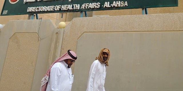 Saudi men walk to the King Fahad hospital in the city of Hofuf, east of the capital Riyadh on June 16, 2013. The World Health Organization announced it had convened emergency talks on the deadly MERS virus, but said the move did not mean it was hiking its global alert level.