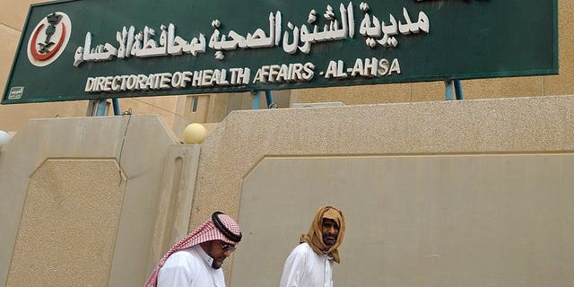 Saudi men walk to the King Fahad hospital in the city of Hofuf, east of the capital Riyadh on June 16, 2013. The World Health Organization announced it had convened emergency talks on the deadly MERS virus, but said the move did not mean it was hiking its global alert level.