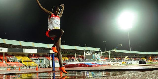 Ruth Jebet leaps over a puddle in the women's 3000 meters steeplechase during the third day of the five-day Asian Athletics Championship 2013 at the Chatrapati Shivaji Stadium in Pune on July 5, 2013.