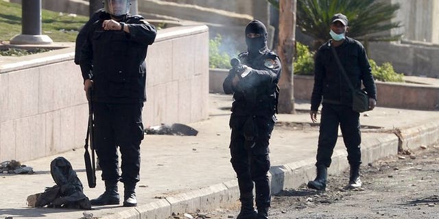 Egyptian riot police fires a tear gas canister towards protesters on January 29, 2013. Unidentified gunmen killed two Egyptian policemen guarding a government building in the northern Sinai town of Al-Arish, a security official told AFP.
